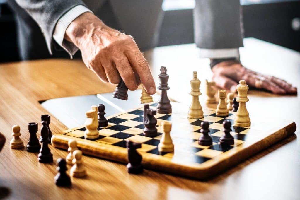 man picking up chess pieces